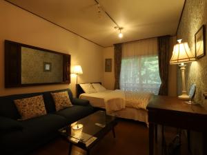 a hotel room with a bed and a couch at Shirahama Hotel in Nago