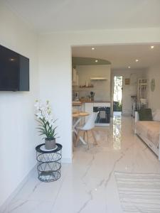 a white living room with a couch and a table at Studio calme avec terrasse et piscine in Saint-Vallier-de-Thiey