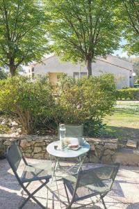 a table and two chairs with a plate of food on it at Studio calme avec terrasse et piscine in Saint-Vallier-de-Thiey