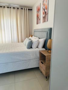 a bedroom with a bed and a wooden nightstand at EchoPheme Suites in Gaborone