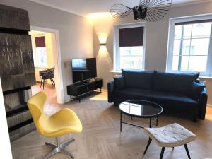 a living room with a black couch and a yellow chair at Gemütlich & stilvoll in Tuchola