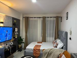 a bedroom with a bed and a flat screen tv at Membley star heights -Naivera in Ruiru