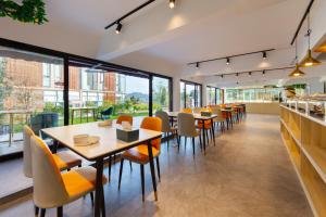 a restaurant with tables and chairs and windows at Bor Manju Vacation guesthouse--Near the Ticket Gate--service in Chinese and English in Zhangjiajie