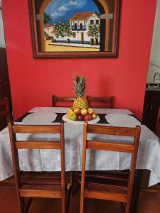 a table with a pineapple and a plate of fruit at Comfortable fully equipped apartment just 6 kilometers from Manuel Antonio, with parking and fast WiFi in Quepos +25 photos