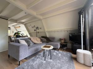 a living room with a couch and a table at Chalet Séquoia 138 Nature, piscine et chien bienvenu à Durbuy in Durbuy