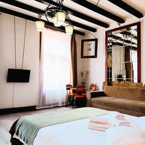 a bedroom with a bed and a couch and a window at Noemi Old Town in Braşov