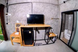 a room with a desk with a television on it at คีรีเขาสกริเวอร์ Keereekhaosokriver in Khao Sok National Park