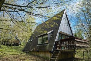 a small house with a gambrel roof and a porch at Sequoia Duo 2 chalets voisins, familles,amis,détente in Durbuy