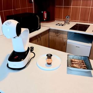 a coffee maker on a kitchen counter with a plate of food at Noemi Old Town in Braşov