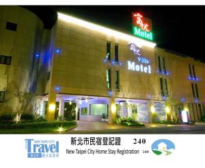 a hotel with a neon sign in front of it at Fortune Villa Motel in Tamsui