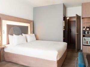 a bedroom with a large white bed in a room at Novotel Paris Rueil Malmaison in Rueil-Malmaison +158 photos