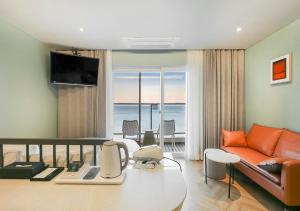 a living room with a couch and a view of the ocean at Brown Dot Yeongildae Beach in Pohang in Pohang