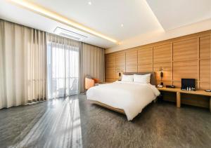 a bedroom with a large white bed and a desk at Brown Dot Yeongildae Beach in Pohang in Pohang