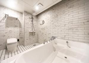 a white bathroom with a tub and a toilet at Brown Dot Yeongildae Beach in Pohang in Pohang +146 photos