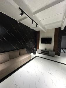 a living room with a couch and a flat screen tv at Villa De Ray in Almaty