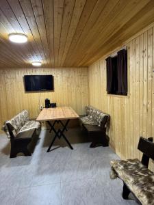a room with a table and chairs and a tv at Villa De Ray in Almaty +9 photos