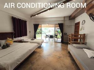 a bedroom with two beds and an air conditioning room at Sulu Sunset Beach Resort in Nauhang