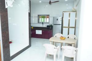 a kitchen and dining room with a table and chairs at Sattva Gruha in Māngaon
