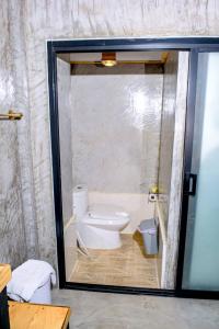 a bathroom with a toilet and a glass door at คีรีเขาสกริเวอร์ Keereekhaosokriver in Khao Sok National Park +30 photos