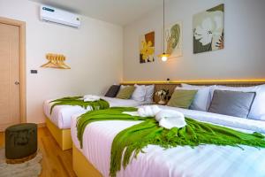 a bedroom with two beds with green blankets at นารา พลูวิลล่า in Cha Am +23 photos