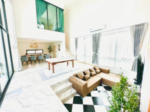 a living room with a couch and a table at นารา พลูวิลล่า in Cha Am