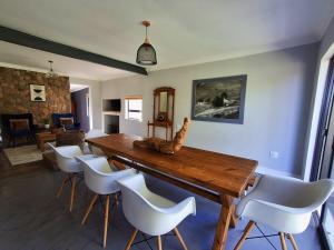 a dining room with a wooden table and white chairs at SoetHoek Farm Retreat in Alexandria