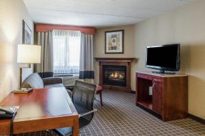 a hotel room with a living room with a fireplace at Comfort Inn & Suites West Springfield in West Springfield