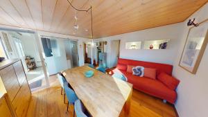 a living room with a wooden table and a red couch at Mauritius MR1 in Naters