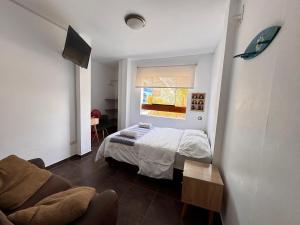 a small bedroom with a bed and a window at La Arteza Pacasmayo in Pacasmayo