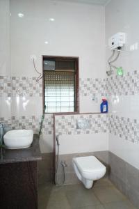 a bathroom with a toilet and a sink at Sattva Gruha in Māngaon +23 photos