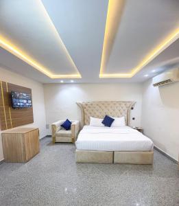 a hotel room with a bed and a chair at Oasis hotel and suites in Lagos