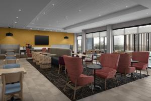 a restaurant with tables and chairs and a tv at Home2 Suites By Hilton Taylor in Taylor
