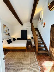 a bedroom with a bed and a stair case at Auberge d'Anais in Vaison-la-Romaine
