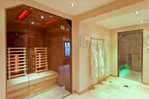 baño con ducha a ras de suelo y puerta de cristal en Alpenland Gerlos - Hotel & Breakfast, en Gerlos
