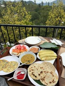 a wooden table with plates of food on it at The Cliff Lodge Ella in Ella