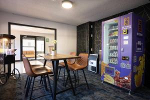 a dining room with a table and a refrigerator at Inn The Mountains, an Ascend Collection Hotel in Hope
