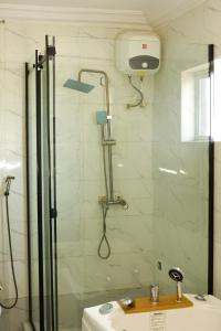 a shower in a bathroom with a sink at Oasis hotel and suites in Lagos +11 photos