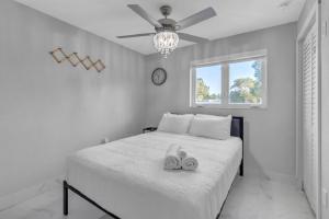 a white bedroom with a bed with two shoes on it at Oasis del Sol in Homestead +59 photos
