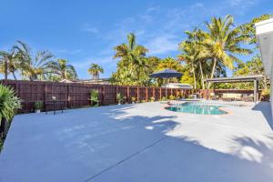 a swimming pool in a backyard with palm trees at Oasis del Sol in Homestead