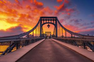 a bridge with a sunset in the background at Wilhelmines Hafenliebe am Park mit Balkon, Netflix, & Privatparkplatz in Wilhelmshaven