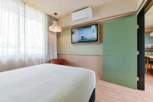a bedroom with a bed and a tv on the wall at The Queens Hotel Gladstone in Gladstone