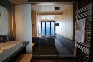a bathroom with a glass shower and a sink at 游水亭いさごや in Tsuruoka