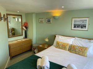a bedroom with a white bed and a mirror at Monarch in Weymouth