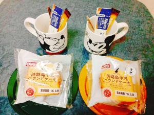 a table with two plates of food and two cups at ゲストハウス瓦町 in Takamatsu