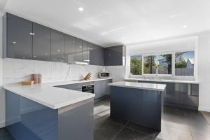 a kitchen with black and white counters and appliances at The Beachside Gathering in Anna Bay