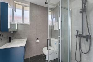 a bathroom with a shower and a toilet and a sink at The Beachside Gathering in Anna Bay +31 photos