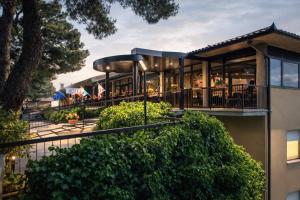 a building with a balcony with trees and bushes at Hotel Granducato in Montepulciano
