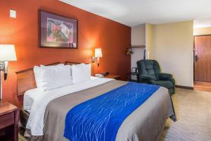 a hotel room with a bed and a chair at Quality Inn Scottsbluff in Scottsbluff