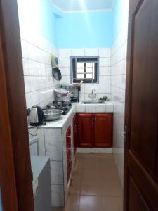 a small kitchen with a sink and a stove at Chambre et apparts meublés, Yaoundé - FOKOU EMANA in Yaoundé