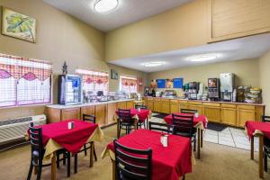 a restaurant with red tables and chairs and a counter at Quality Inn Scottsbluff in Scottsbluff
